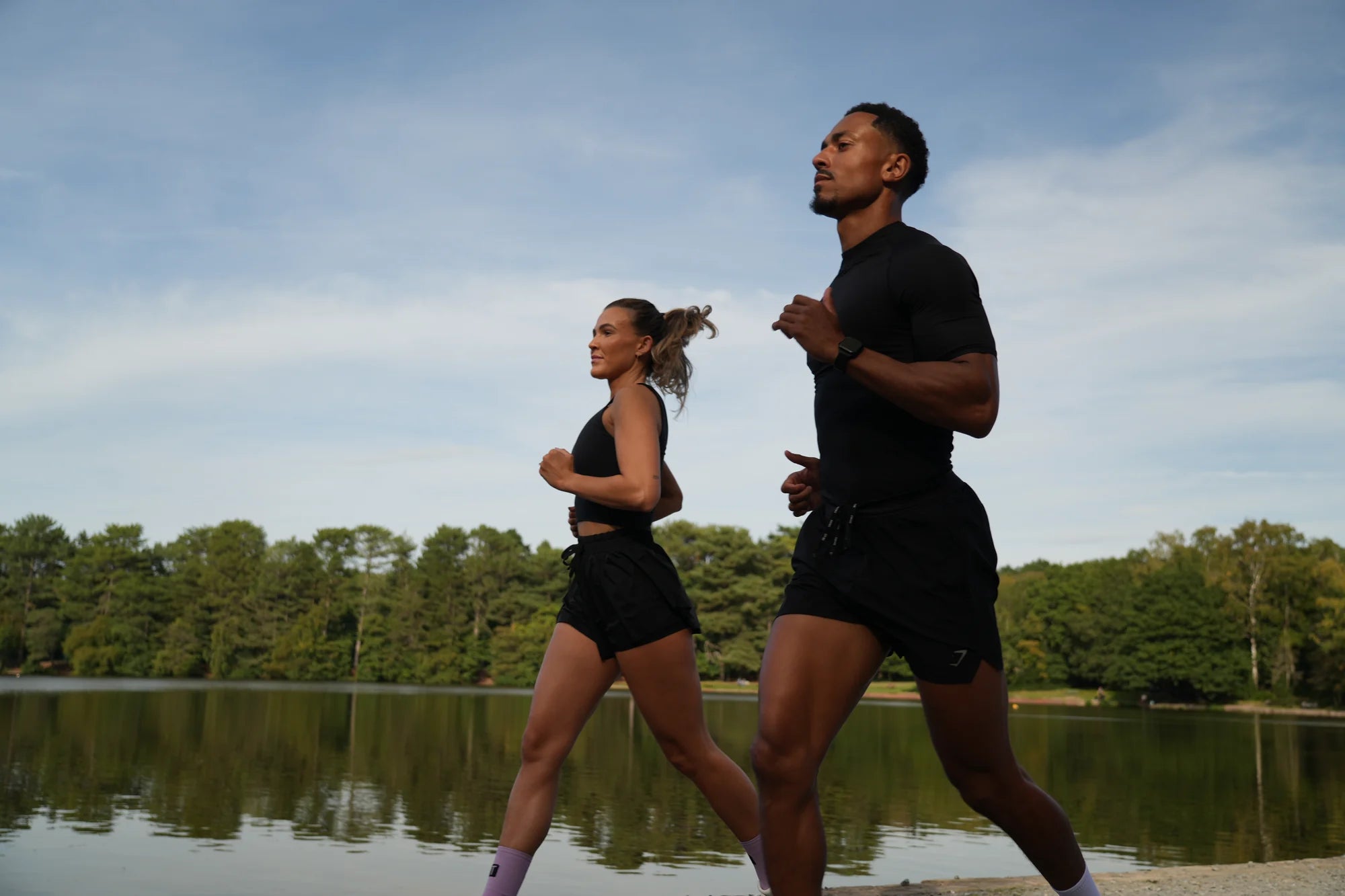 Two runners on a lakeside path