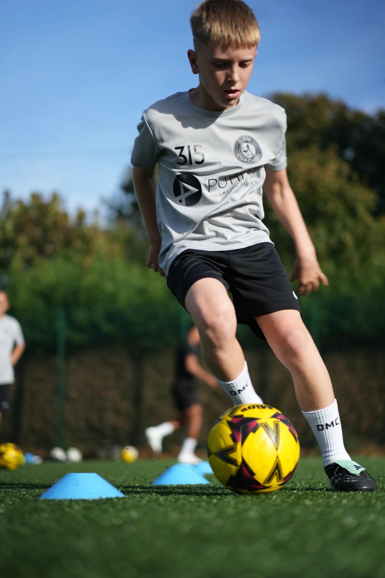 Junior player dribbling between cones