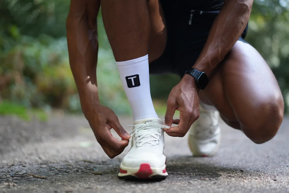 Runner lacing up in TRED socks