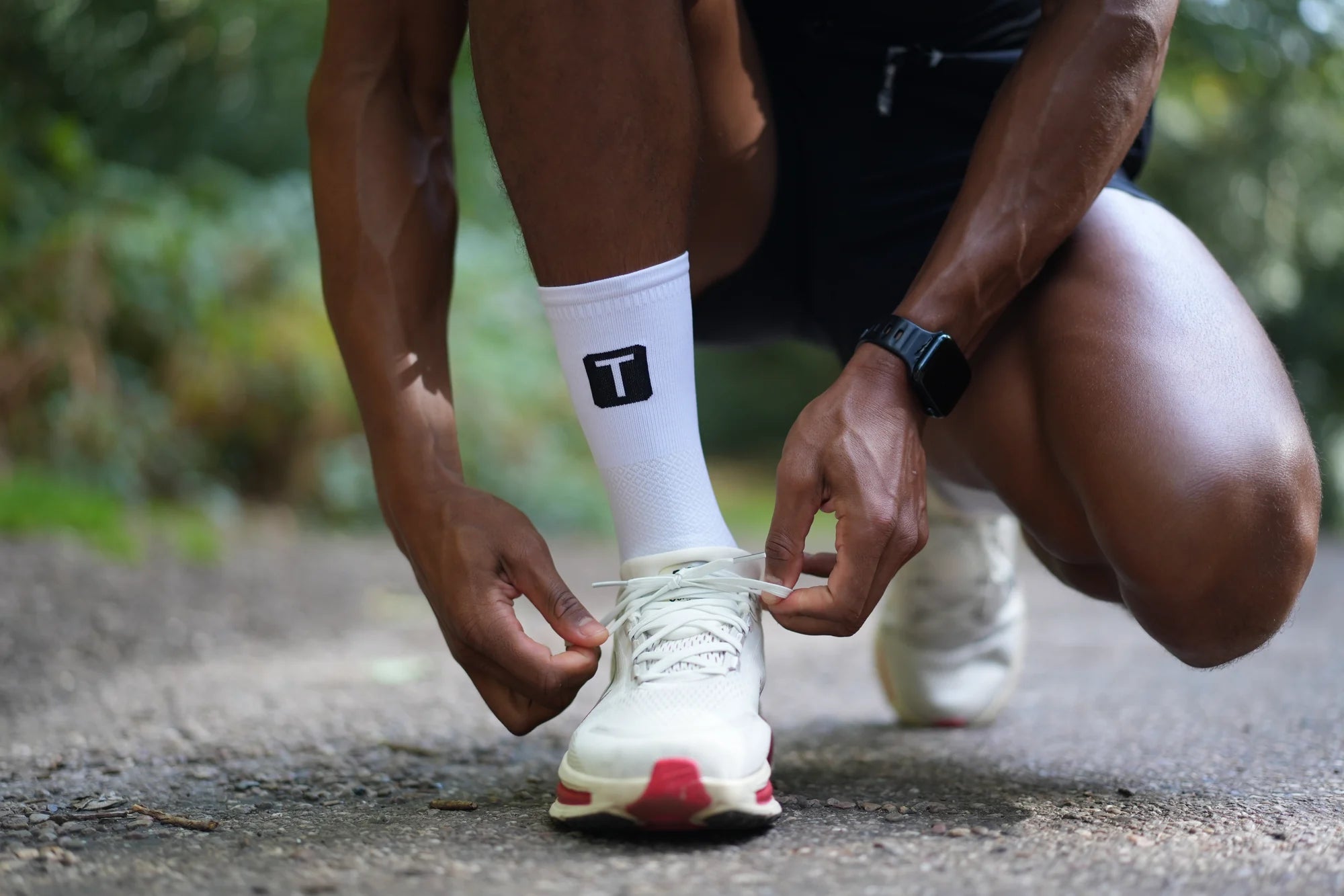 Runner lacing his trainers in white TRED socks