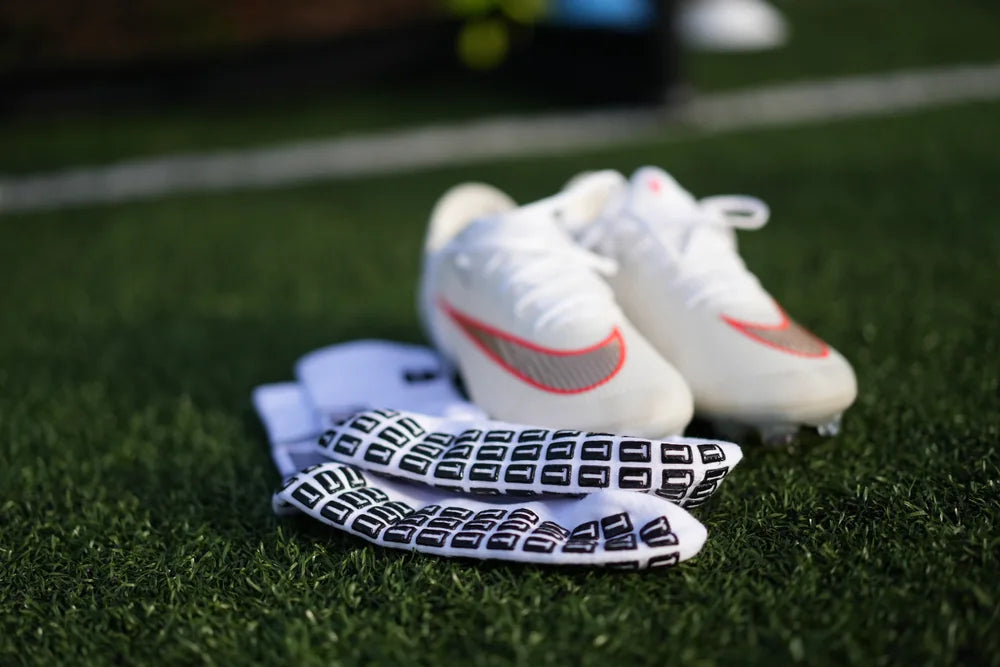 Grip soles of TRED socks next to football boots